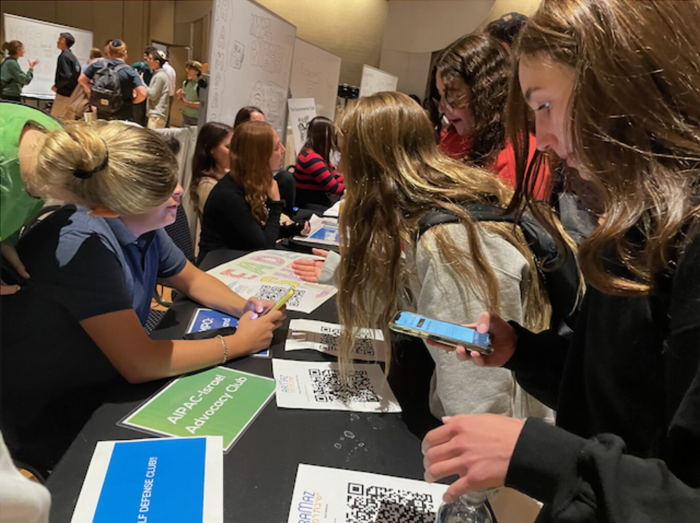 Students at a club fair scanning club QR codes with their phones