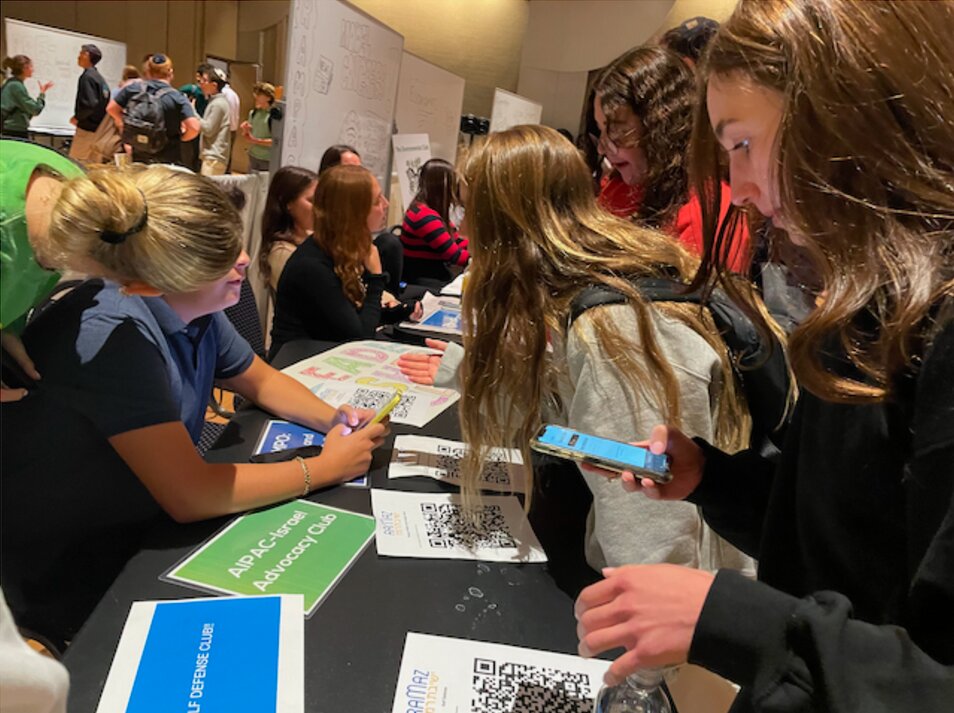 Students scanning QR codes to join clubs at the King School club fair